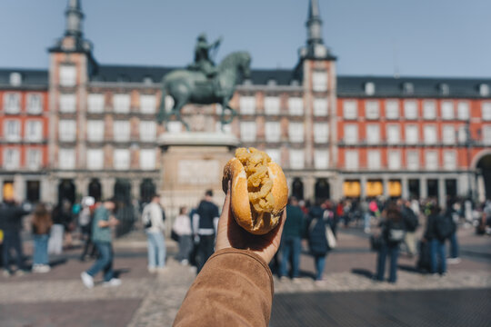 Tourist holding bocadillo de calamares in plaza mayor, madrid, spain