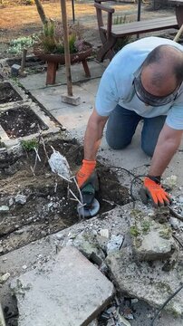Mann flext im Garten Metall