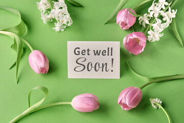 Get well soon card with pink tulips and white flowers on green background, expressing wishes for...