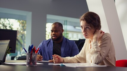 Car dealership salesman giving couple documentation to read after agreeing terms. Agent giving sale contract for clients to sign after they decide to make purchase, camera B