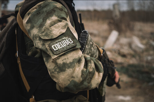 A special forces soldier with a machine gun in close-up. translation of the inscription on the patch on the sleeve of the uniform is special forces.