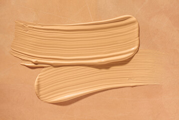 Beauty skin care swatch sample. Make up smear foundation drops smudge texture beige background