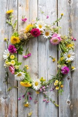 Fototapeta premium Beautiful handmade floral wreath featuring vibrant summer flowers against a rustic wooden background. Symbolizing celebration, nature, and creativity, perfect for use in seasonal designs