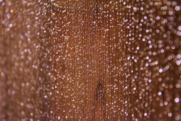 Brown background with drops on glass. Selective focus. color of the year 2025