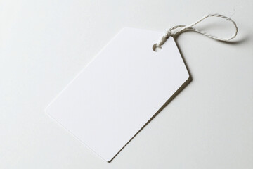 Naklejka premium Blank white tag with string on a light background for customizable labeling. isolated on white background.