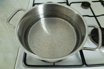 Water is boiling in a stainless steel pot on a gas stove.