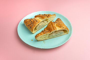 Concept of tasty food with samsa on blue plate on pink background. cut the samsa. bright pink background color.