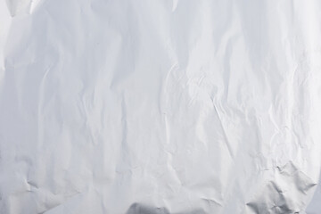 A high-definition shot of crumpled aluminum foil, forming an abstract, shiny metallic texture ideal...