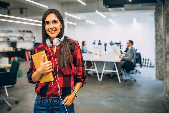Young female student feeling ready to write exam testing and making individual tasks using technology computer and tablet connected to global network while smiling in university coworking space.