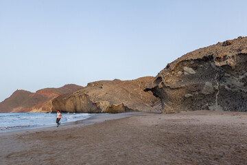 Young man running on monsul beach at dawn in the cabo de gata natural park