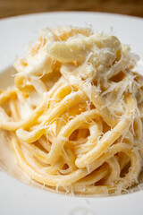 Spaghetti carbonara with parmesan cheese on a white plate