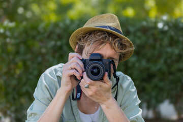 Photographer taking pictures outdoors with digital camera in nature