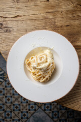 Spaghetti carbonara with parmesan cheese on a white plate