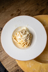 Spaghetti carbonara with parmesan cheese on a white plate