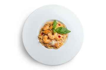 Spaghetti with shrimps and basil on a white plate.