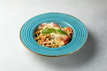 Spaghetti with shrimps and basil on a white plate.