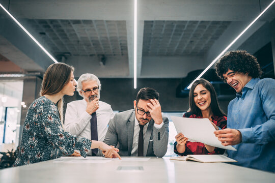 Worried businessman with his colleagues at modern office.