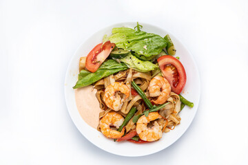 Spaghetti with shrimps and basil on a white plate.
