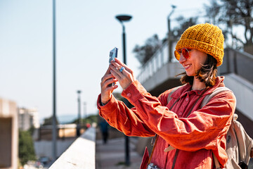 tourist with backpack using smartphone to take pictures of landmarks, girl taking picture of...