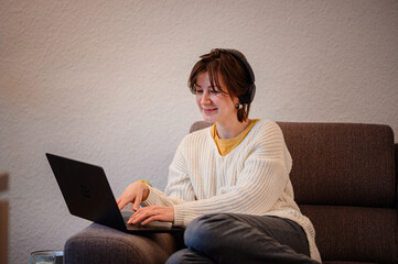 Smiling Woman Working on Laptop with Headphones
