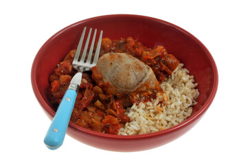 Paupiette de veau avec du riz accompagnée d'une compotée de poivrons et tomates servie dans une assiette avec une fourchette isolée sur fond blanc