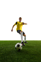 Low-angle view of young man, soccer player controlling ball, maneuvering quickly, positioning himself for strategic play against white background. Concept of dribbling, strategy, technique, game.