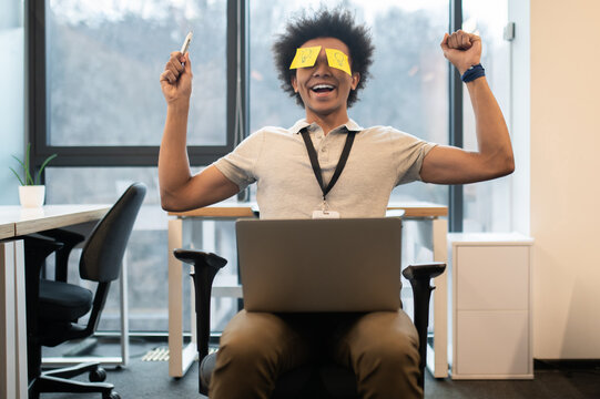 Man with yellow notes on face having fun in office