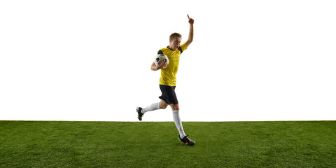 Emotional young ma, soccer player in yellow jersey and black shorts running on field with trophy, hand raised in victorious gesture. Concept of sport, action, competition, game, active lifestyle. Ads