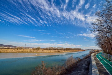 landscape with a bike path on the bank of a river