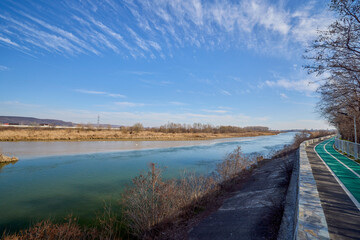 Obraz premium landscape with a bike path on the bank of a river