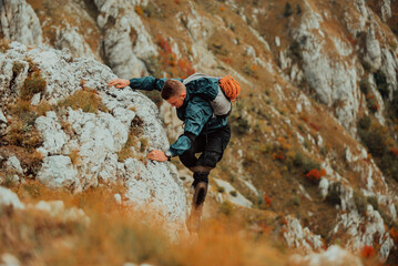 A male climber climbing up on the mountain rock cliff adventure travel adrenaline extreme sport...