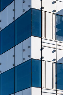 Close-up of a blue glass facade with metal framing in an urban high-rise.