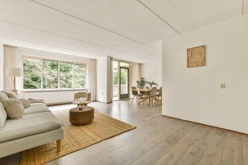 A bright and stylish modern living room featuring a comfortable sofa, natural light, and minimalist decor that enhances the inviting atmosphere.