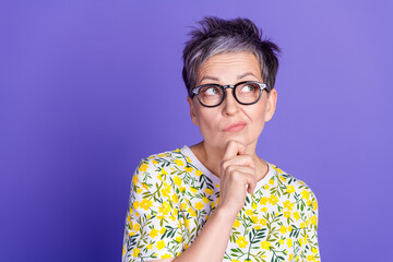 Stylish Mature Woman in Casual Floral T-Shirt Making a Pensive Gesture on a Purple Background