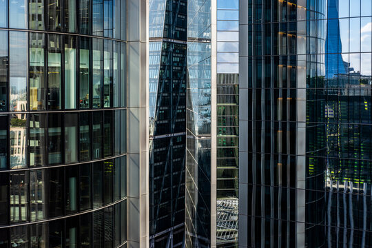 Symmetrical reflections of skyscrapers in an intricate grid of glass windows.