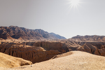 Sunlit canyon view in Kal Jeni, Iran. Rugged landscape with layered rock formations.