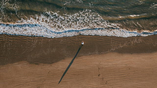 Someone walking alone on a beautiful beach, Very low tide at Compton beach on an August summers day