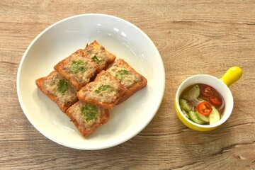 Thai crispy fried pork toast on plate eat couple with pickled vegetable sauce