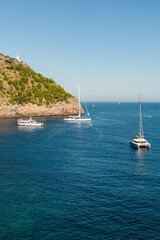 Elegant yachts moored anchor in picturesque harbor Port de Soller.Calm sea surface, sunny day. Mallorca, Spain, Balearic Islands. Travel, recreation at sea, yachting,