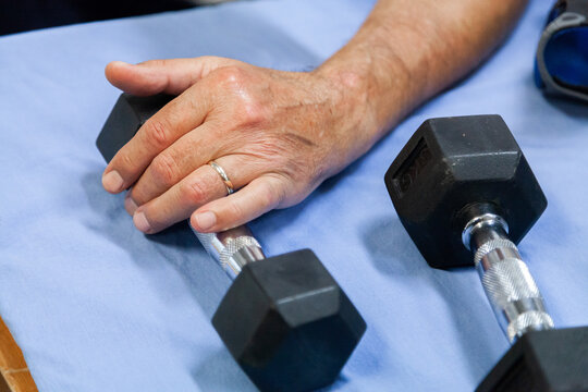 Man exercising wrist with small weights
