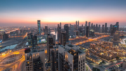 Fototapeta premium Aerial view of a big modern city day to night timelapse. Business bay, Dubai, United Arab Emirates.