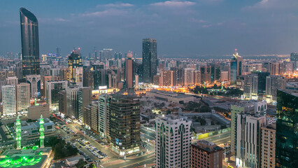 Naklejka premium Modern city architecture of Abu Dhabi skyline day to night timelapse, UAE.