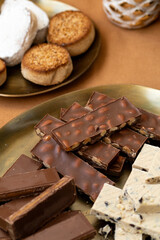 Christmas Spanish holiday treats, chocolate turron with whole almonds, creamy nougat, and polvorones