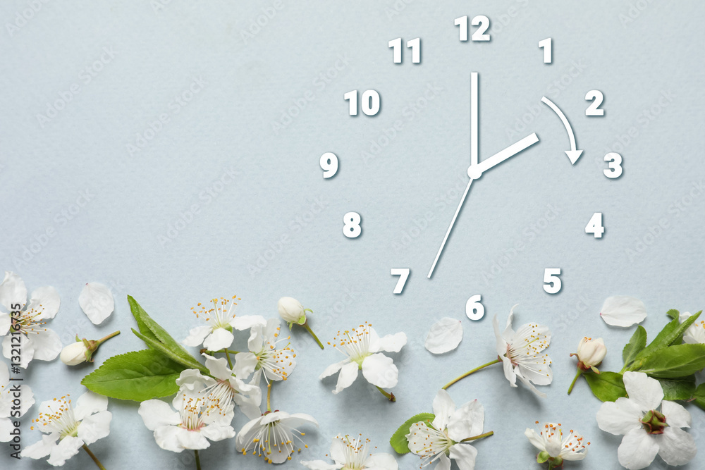 Poster clock and flowers on grey background, top view. arrow showing time change one hour ahead in spring. 