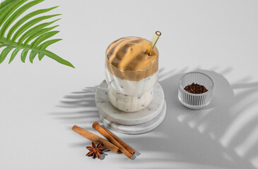 Korean whipped drink Dalgona coffee on a marble stand on a light  background