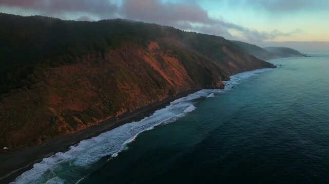 USAL Beach Campground Northern California aerial drone bluffs cliffside mountain rocky rugged remote coast vibrant sunset Sinkyone Wilderness waves crashing surf swell dense redwood forest circle left