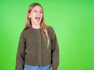 beautiful teen girl wearing green sweater winking looking at the camera with sexy expression, cheerful and happy face.