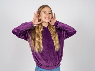 beautiful teen girl wearing purple sweater Trying to hear both hands on ear gesture, curious for gossip. Hearing problem, deaf