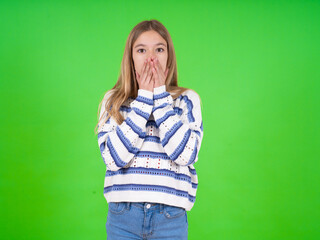 beautiful teen girl wearing striped sweater keeps hands on mouth, looks with eyes full of disbelief, being puzzled with amount of work