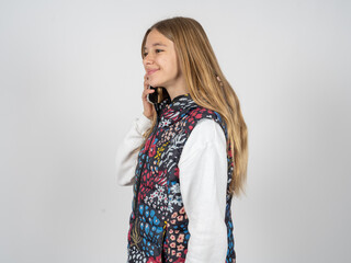 Happy joyful charming beautiful teen girl wearing colorful vest talk speak phone smile good mood